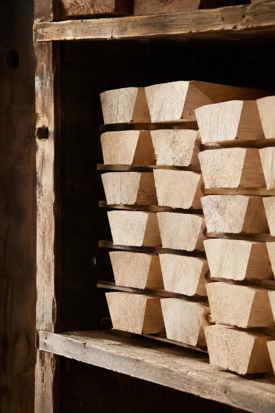 Maple billets stacked with spacers on workshop shelves
